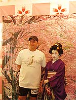 満開の桜を背景に着物女性とポーズ